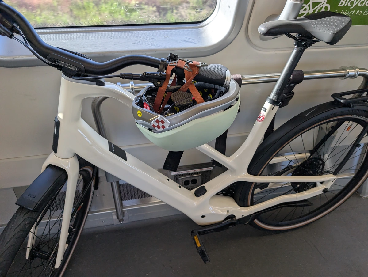 Bike on a train with helmet straps holding down the rear brake lever